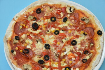 pizza with olives and cheese on  blue background