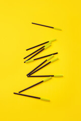 Black green makeup brushes, eyelash combs and eyebrows on trendy bright yellow background with copy space, banner, flyer coupon for lashmakers salon, beutician industry - 432072345