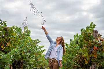 blonde woman pulling grapes up