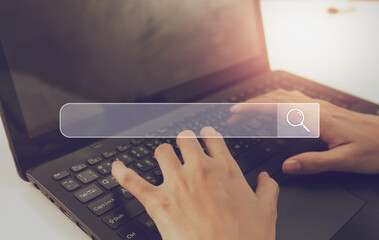 Search bar of internet browser and woman working on modern laptop at table.