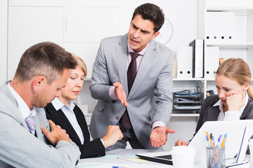 Businessman feeling angry to coworkers in office, pointing out mistakes in work