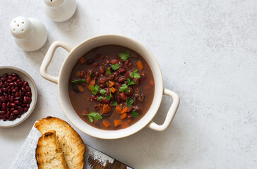 Bowl of red beans, carrots and lentils soup. Flat lay. Copy space