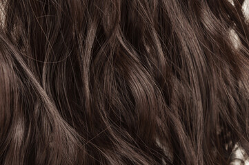 closeup of multiple pieces of clip in wavy brown synthetic hair extensions