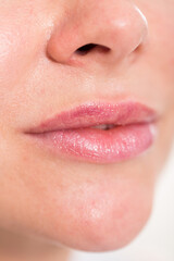 Fototapeta premium Close-up of woman's light pink lips with natural lipstick make up. macro lipgloss make-up
