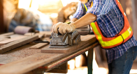 Asian elderly carpenter man working woodwork by electric planer at wood workshop. Construction industry concept. Tools for woodwrok pencil hammer meter and screw-driver.