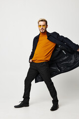 Energetic man posing in fashionable clothes on a light background jacket sweater pants trend style