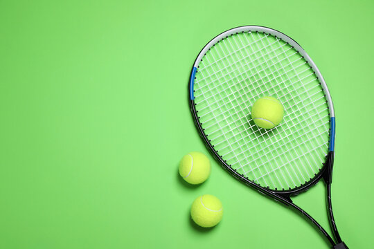 Tennis racket and balls on green background, flat lay. Space for text © New Africa