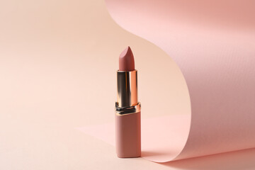 Beautiful lipstick on beige background. Professional makeup product - obrazy, fototapety, plakaty