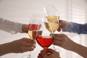 People clinking glasses of wine on white background, closeup