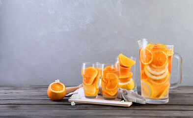 Refreshing orange lemonade on grey wooden table. Summer drinks concept.