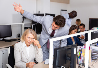 Male angry boss blaming adult female office worker in office