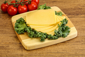 Sliced Gauda cheese over board