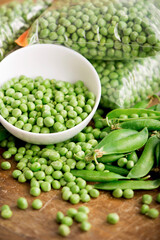 Green pea in bowl of top view on rustic wooden background with copy space, natural wooden table.