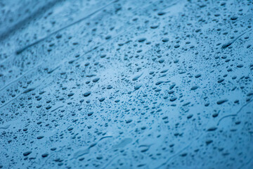 The day was heavy rain, the weather was overcast.Rain water falls on the windshield of car.