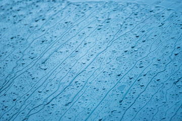The day was heavy rain, the weather was overcast.Rain water falls on the windshield of car.