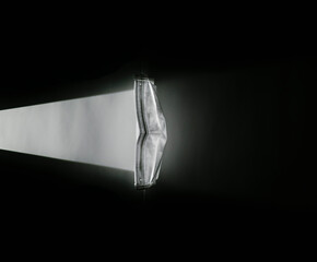 Light hitting white surgical mask and diffusing Covid-19 Wear a mask to protect others