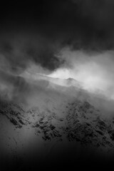 Infrared cloudscape in High Tatra Mountains, Poland. Dramatic sky over the ridge, wintry mood in the area. Selective focus on the rocks, blurred background.