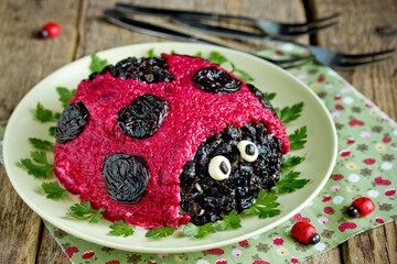 Herring salad with beetroot shaped funny ladybug for kids meal
