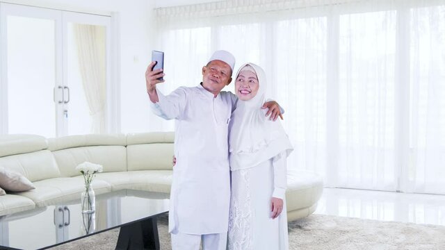 Muslim senior couple take selfie during Eid at home