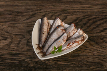 Anchovies in the bowl served basil leaves