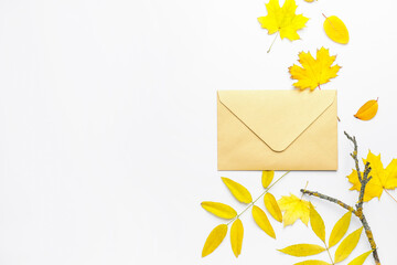 Envelope and autumn leaves on white background