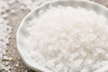 Plate with salt on grunge background, closeup