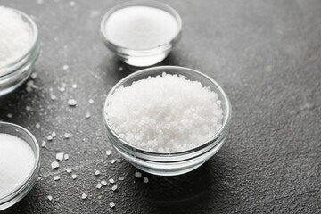 Bowls with salt on dark background