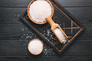 White salt on dark wooden background