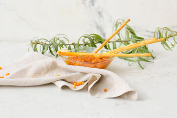 Bowl of healthy sea buckthorn jam and bread sticks on white background