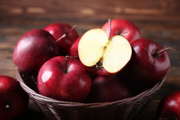 Basket with fresh red apples on table