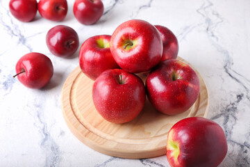 Board with fresh red apples on white background