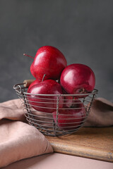 Basket with fresh red apples on table