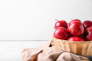 Basket with fresh red apples on white background