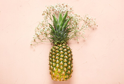 Fresh Pineapple With Flowers On Color Background