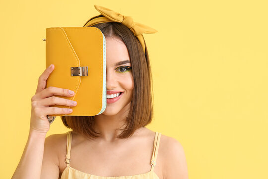 Stylish Young Woman With Bag On Yellow Background