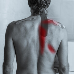 Monochrome image of young man having acute pain in spine