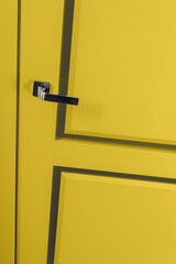 Modern chrome door handle on yellow bright door