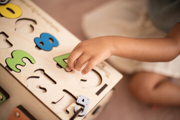 Toddler playing interactive games for good development at home. Close up. Focus is on hand.