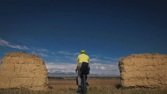 The man travel on mixed terrain cycle touring with bikepacking. The traveler journey with bicycle bags. Sport tourism bikepacking.