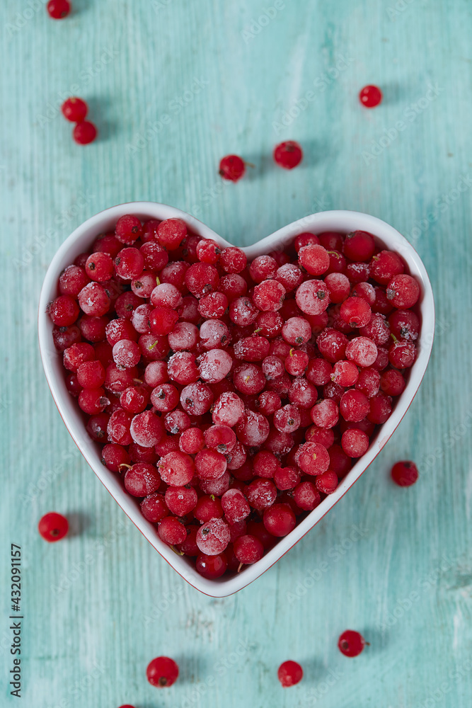 Wall mural frozen red currants on wooden surface