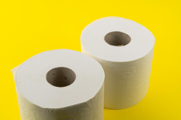 View of two rolls of toilet paper on yellow background