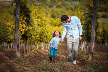 Fototapeta premium Father and son walk through the vineyard.