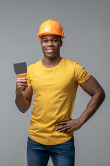 African american in construction helmet with working blade