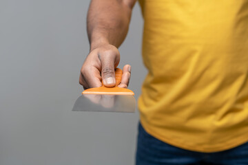 Dark skinned mans hand holding new spatula