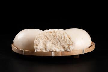 Chinese food steamed buns in bamboo on black background