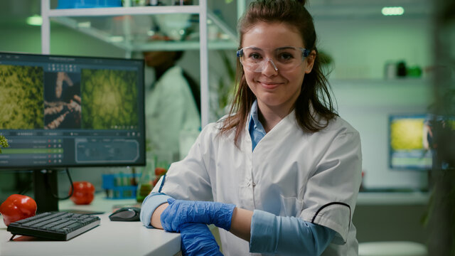 Portrait of smiling biologist woman analyzing genetically modified organism for microbiology experiment. Chemist scientific analyzing organic plants working in microbiology agriculture laboratory