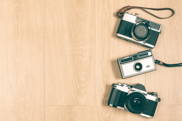 SLR camera, rangefinder camera and compact camera on wooden floor