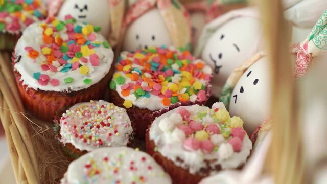 cupcakes decorated with glaze and eggs painted like rabbits. revolves
