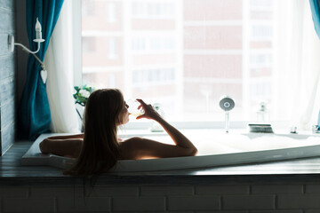 a young woman resting bath of foam and drinks wine. lifestyle. Day spa. 