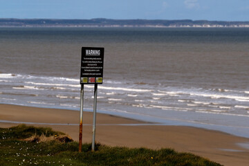 Sign on dangerous eroding clay cliff warning of danger of collapse. Yorkshire. UK.